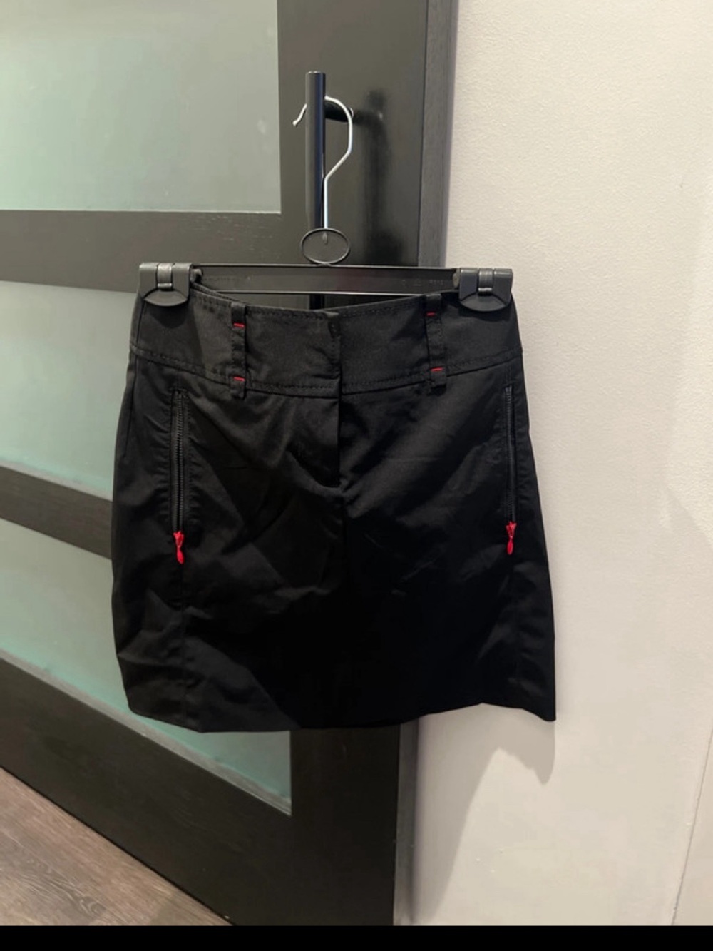 Black weatherproof mini skirt w/ red accent zipper side pockets & belt loops